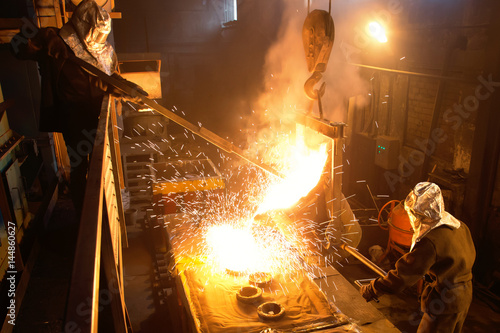Workers operates at the metallurgical plant. Melting Iron in the foundry. Liquid metal in the factory, smelting iron and processing