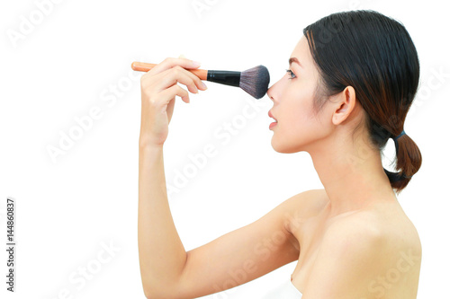 Asian woman Face Portrait Beauty Skin Care and applying cosmetic powder brush on smooth face isolated on white background. Natural makeup, skincare, cosmetology and plastic surgery concept.