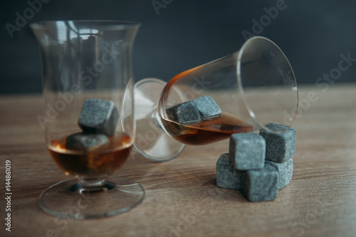 Stones for cooling whiskey and glases tulup on dark wooden background photo