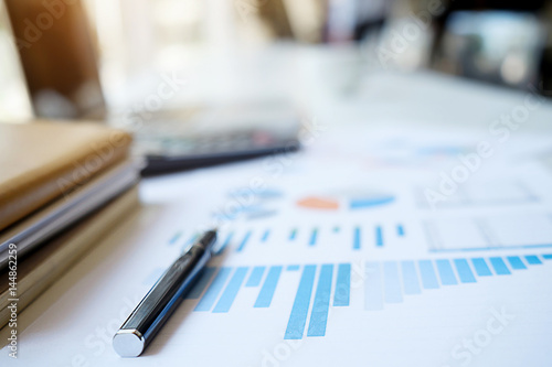 Business concept with copy space. Office desk table with pen focus and analysis chart, computer, notebook on desk.Vintage tone Retro filter.