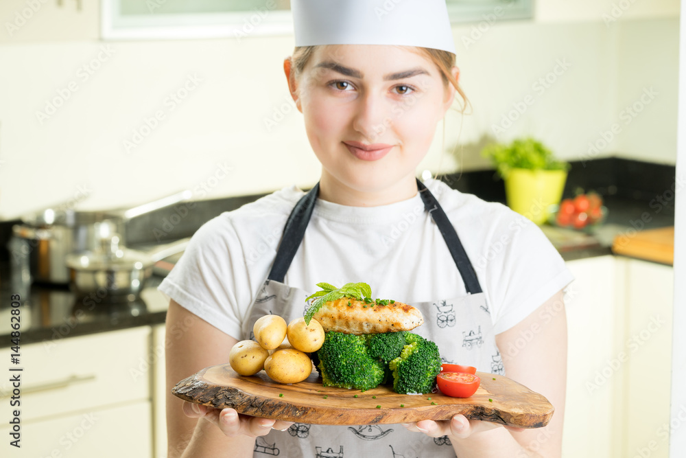 concentrated female chef garnishing food in the kitchen concentrated female chef garnishing food in the kitchen
