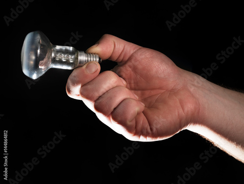 Man's hand holding electrical lamp