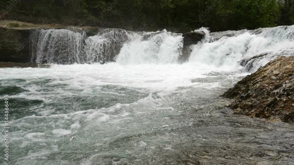 Wide shot of super slow motion water floating down a cascade of a river, in HD Wide shot of super slow motion water floating down a cascade of a river, in HD