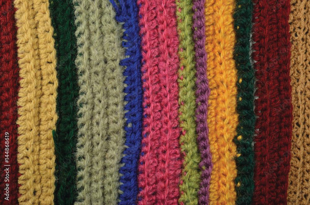 Knitted fine wool garment colorful stripes background natural texture, yellow, beige, claret, blue, green scarf macro closeup, large detailed textured knit pattern, horizontal woolen