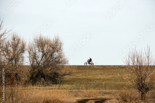Motorcyclist rides on the road against the sky © pro2audio