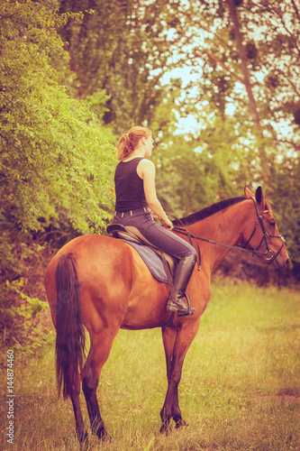 Young woman ridding on a horse
