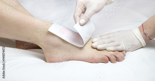 Process depilation female legs and hands in a beauty salon