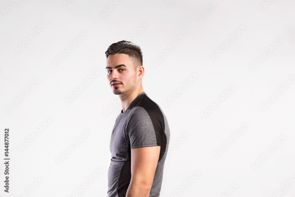 Young handsome fitness man in gray t-shirt, studio shot. Young handsome fitness man in gray t-shirt, studio shot.