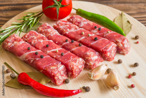 Raw cevapcici dish of mixed meats, the food of the Balkans. Minced meat and bacon.