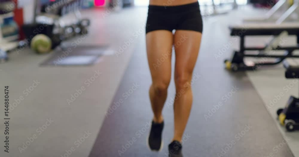 Smiling slim woman with fit body drinks water in fitness gym Smiling slim woman with fit body drinks water in fitness gym