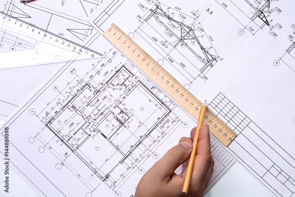 Man architect draws a plan, schedule, design, geometric shapes with a pencil and a wooden ruler. The figure is close to the transparent line of triangle Man architect draws a plan, schedule, design, geometric shapes with a pencil and a wooden ruler. The figure is close to the transparent line of triangle
