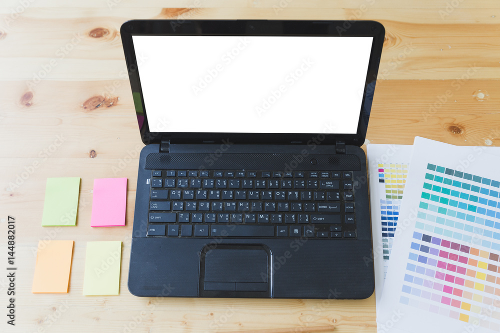 Fototapeta premium graphic designer desk table with computer, sticky note and color guide palette swatches