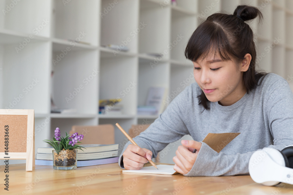 asian girl female teenager studying at school. Student writing note in cafe - education and learning concept asian girl female teenager studying at school. Student writing note in cafe - education and learning concept
