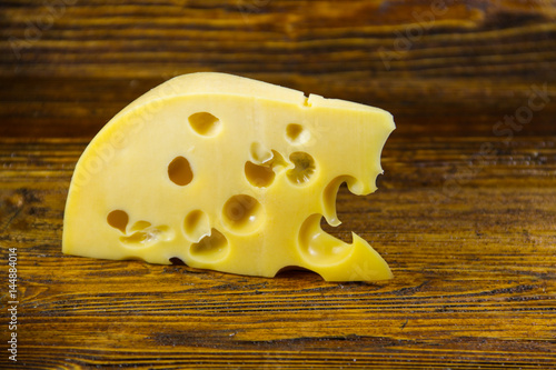 Piece of cheese on the wooden background
