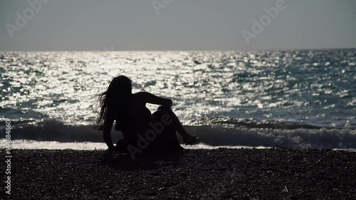 Woman in vacation: Silhouette of a Woman in a sunset at a beach.   photo