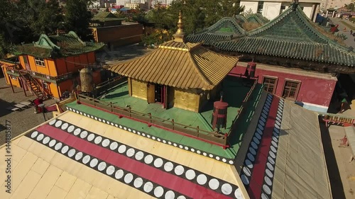 Cinematic aerial flight above Gandan Gandantegchinlen Chinese-style Tibetan Buddhist Monastery. Center of Mongolian capital of Ulaanbaatar. Religion world famous attraction. Colorful roof. sunny day photo