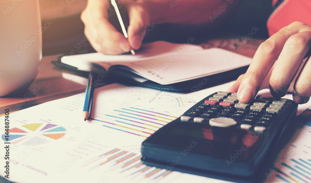 Calculator with woman hand doing finance in home and calculate about cost. Calculator with woman hand doing finance in home and calculate about cost.