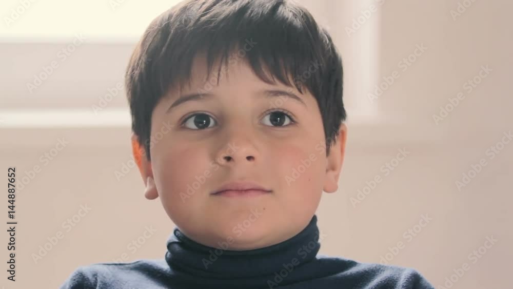 The boy looks at the camera with enthusiasm and surprise The boy looks at the camera with enthusiasm and surprise