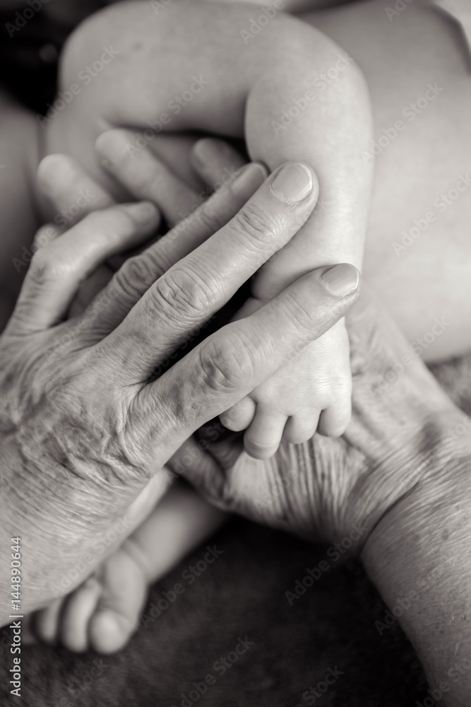 great-grandmother holds the hands of his beloved grandson great-grandmother holds the hands of his beloved grandson