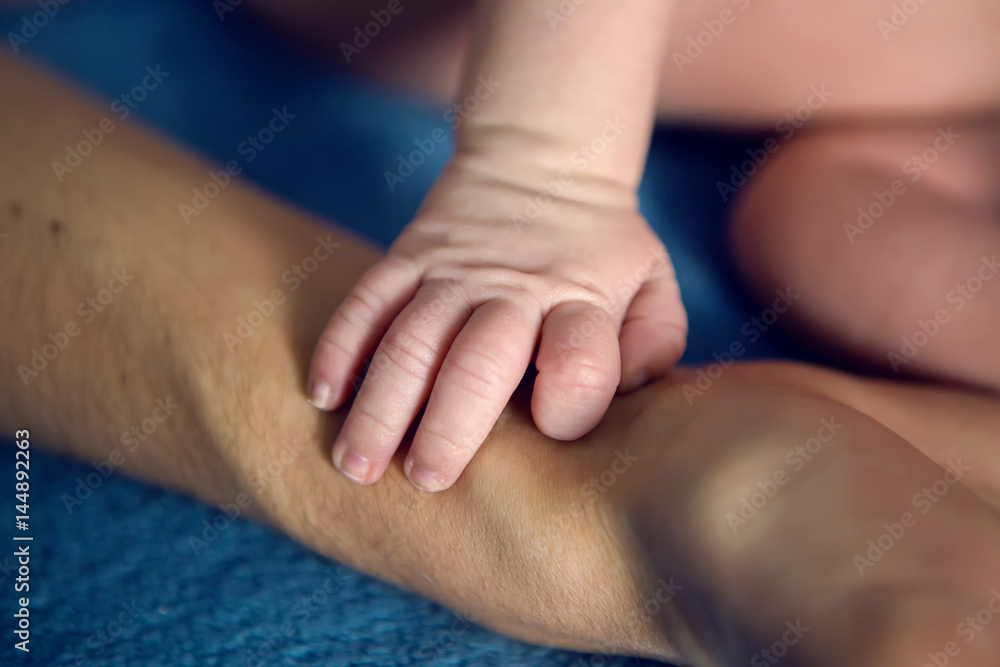 father holds the hand of his baby son father holds the hand of his baby son