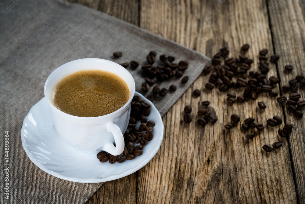 Coffee cup and beans on a wooden table. Coffee cup and beans on a wooden table.