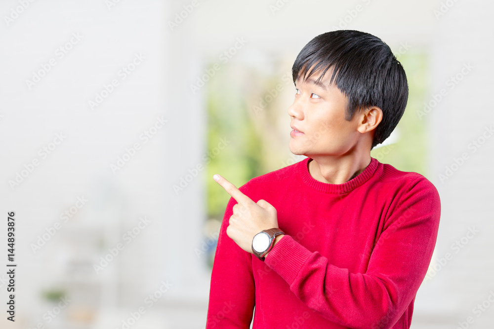 portrait of young asian man pointing with his finger portrait of young asian man pointing with his finger