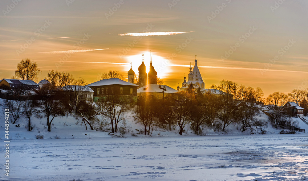 landscape of a sunset on a river in winter with bright sun shining through the dome horizontal view