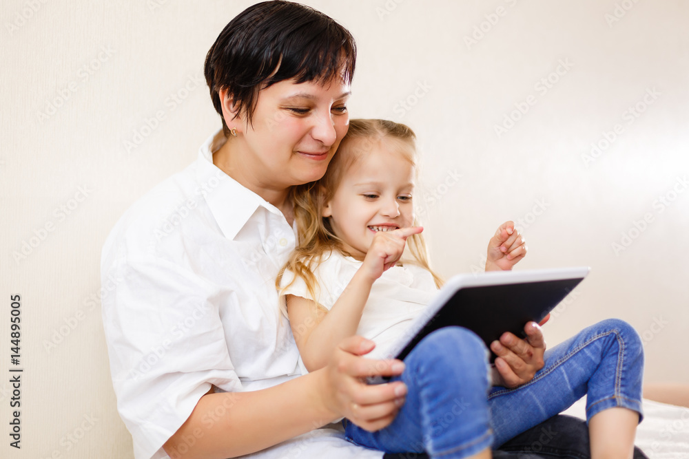Mom and daughter using tablet Mother and daughter using tablet computer together Mom and daughter using tablet Mother and daughter using tablet computer together