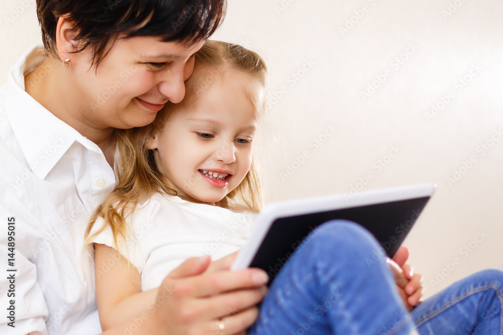 Mom and daughter using tablet Mother and daughter using tablet computer together Mom and daughter using tablet Mother and daughter using tablet computer together