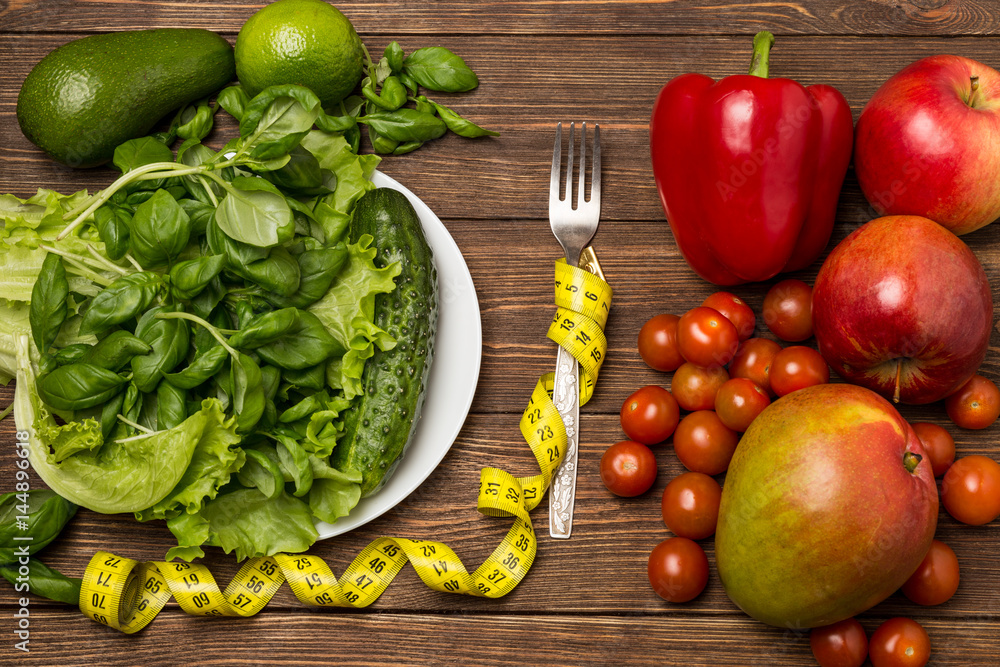 Healthy eating, dieting, slimming and weigh loss concept. Fruits and vegetables on wooden background Healthy eating, dieting, slimming and weigh loss concept. Fruits and vegetables on wooden background