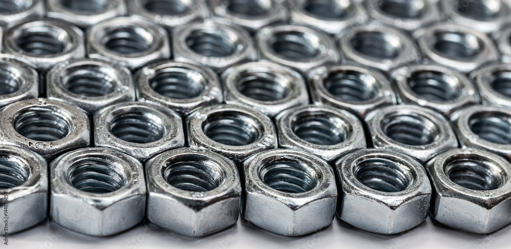 Metal texture. Background of identical nuts with thread. Selective focus. Metal texture. Background of identical nuts with thread. Selective focus.