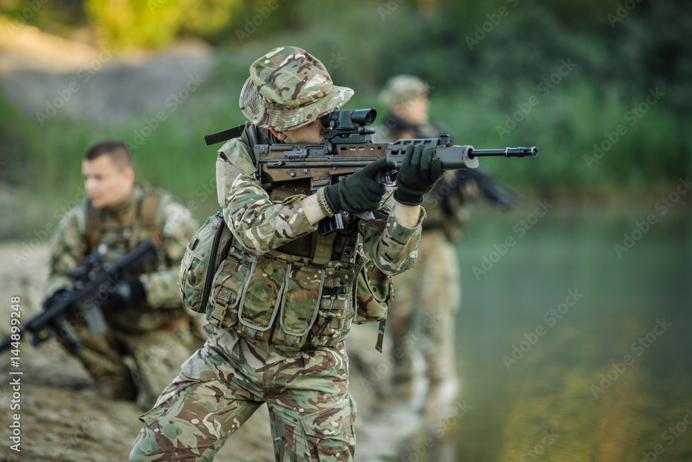 Special forces soldiers with weapon take part in military maneuver. war, army, technology and people concept. Special forces soldiers with weapon take part in military maneuver. war, army, technology and people concept.