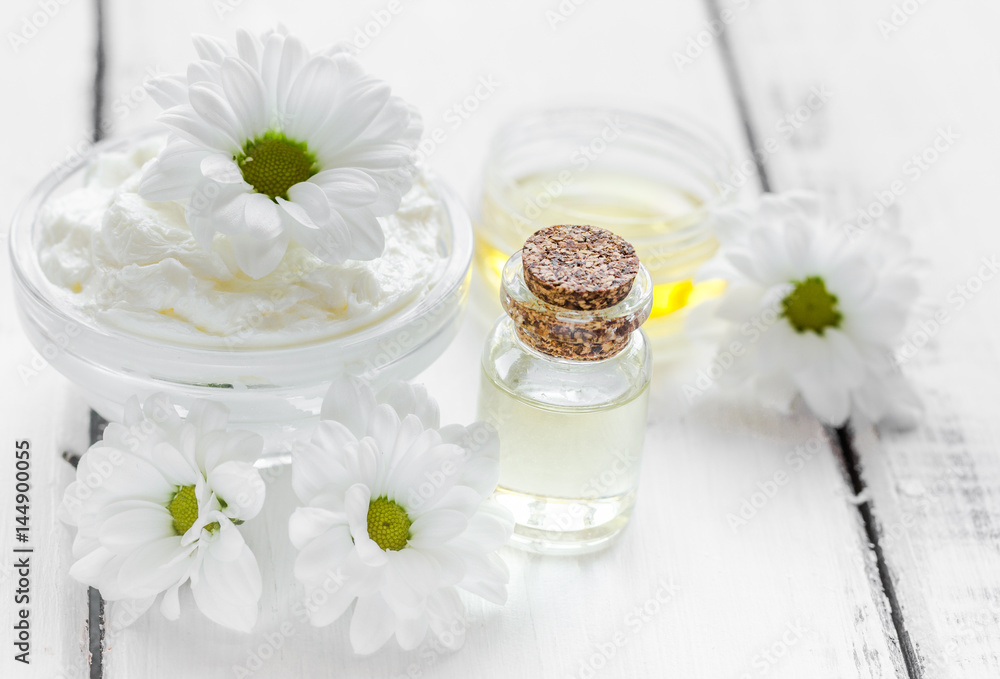 camomile essential oil in glass bottle in cosmetic set on table background camomile essential oil in glass bottle in cosmetic set on table background