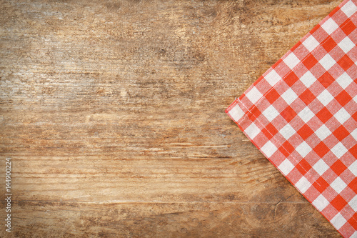 Red checkered tablecloth on wooden background