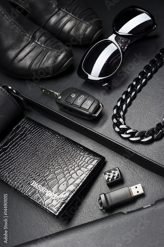 Woman accessories in business style, shoes, gadgets, jewelry and other luxury businesswoman attributes on leather black background, fashion industry, selective focus