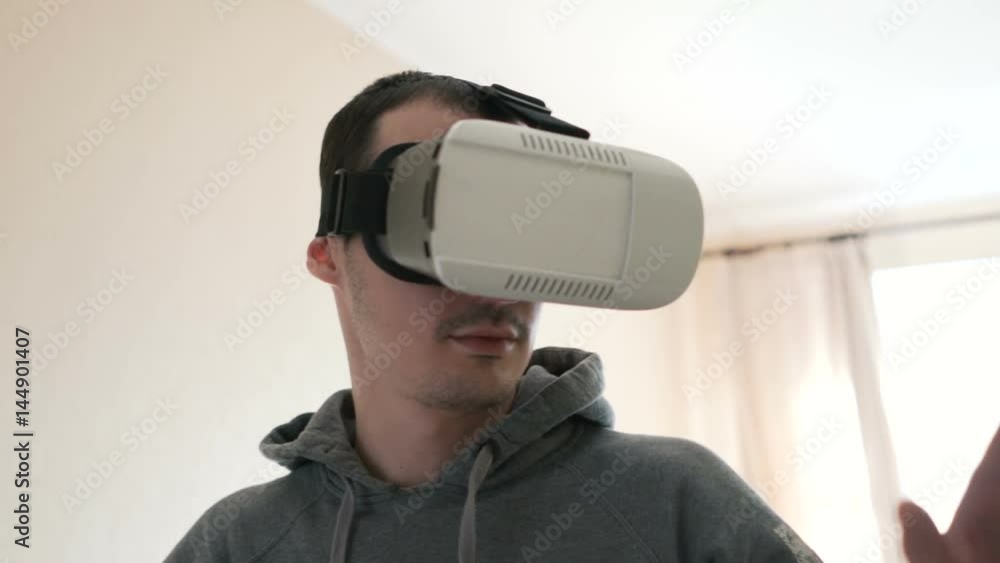 Man wearing virtual reality headset at living room. Man wearing virtual reality headset at living room.