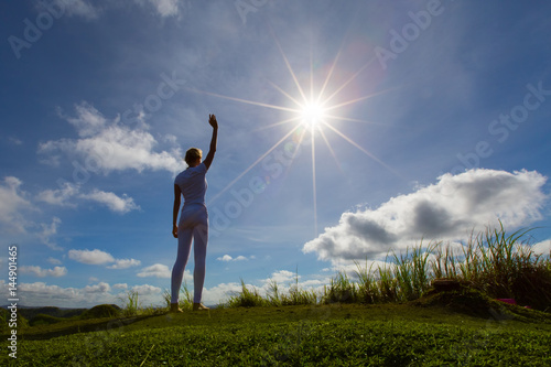 Enjoy the sun,woman stay with rising hands