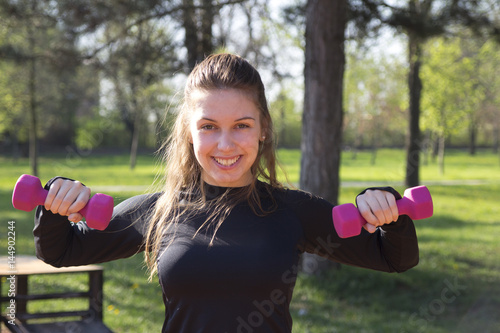 Young pretty girl doing exercise and running in the park