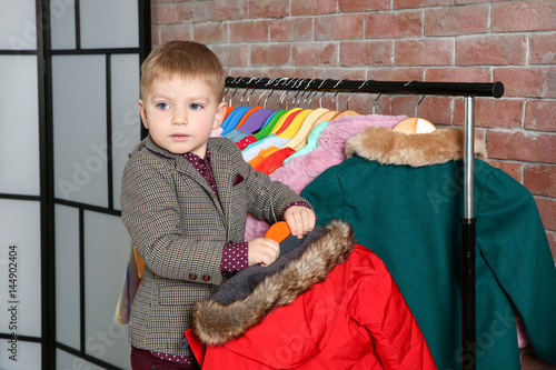 Cute little boy choosing cl...
