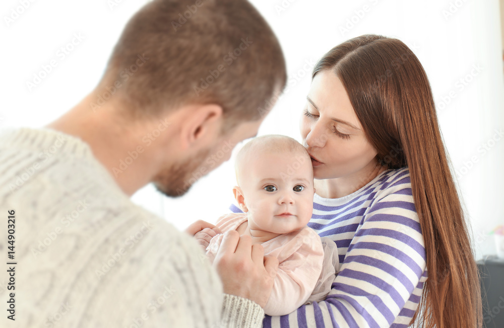 Happy young family with adorable baby on light background Happy young family with adorable baby on light background