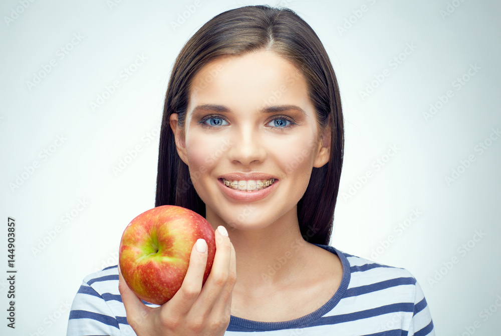 Smiling woman with braces holding apple. Smiling woman with braces holding apple.