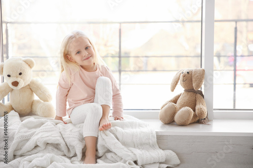Cute little girl sitting on...