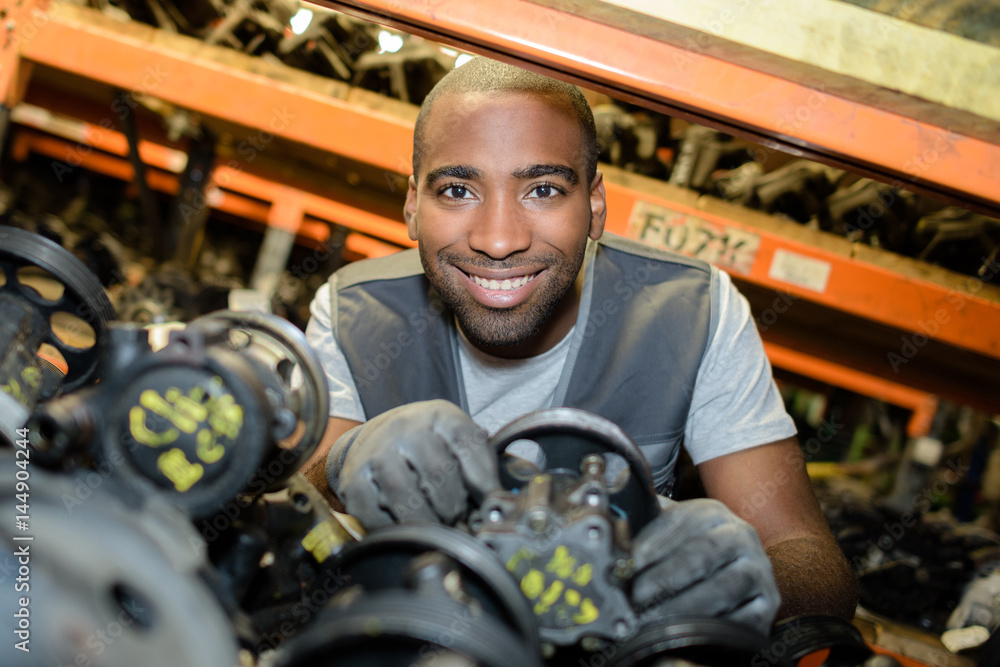 Portrait of man amongst second hand car parts Portrait of man amongst second hand car parts