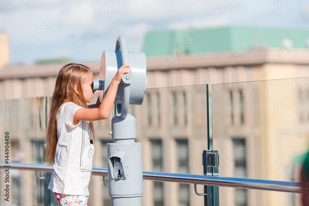 Φωτογραφία Little girl looking at coin operated binocular on terrace with beautiful view