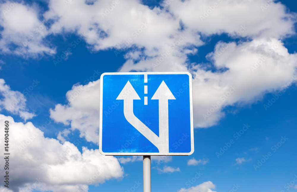 Road sign against the blue sky with clouds Road sign against the blue sky with clouds