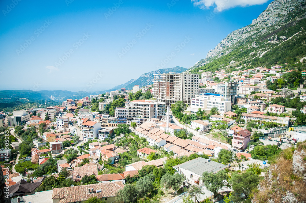 2016, Albania, Kruja. Beautiful view to the city and moutains. Blue sky and green landscape with red roofs of the city
