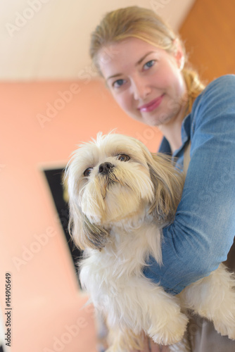 happy woman and dog in grooming salon