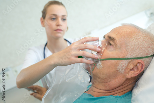 Konstfotografi Nurse placing oxygen mask on patient