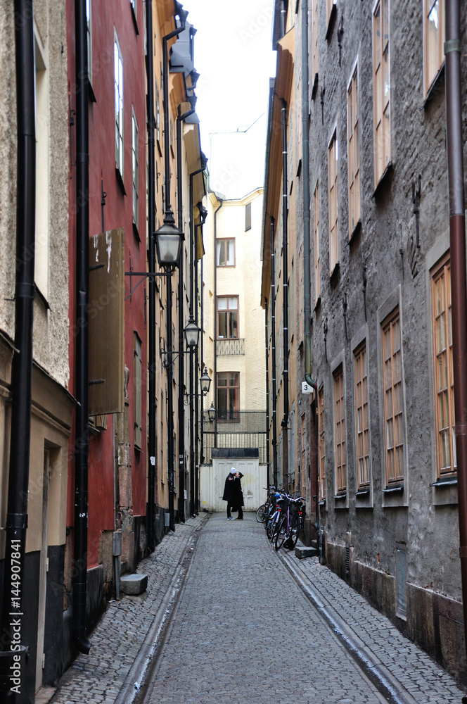 Stockholm,  Szwecja - zakochana para w wąskiej ulicy starego Miasta. - obrazy, fototapety, plakaty 