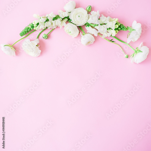 Floral frame of white flowers - ranunculus and snapdragon on pink background. Flat lay, top view. Spring time background. © artifirsov
